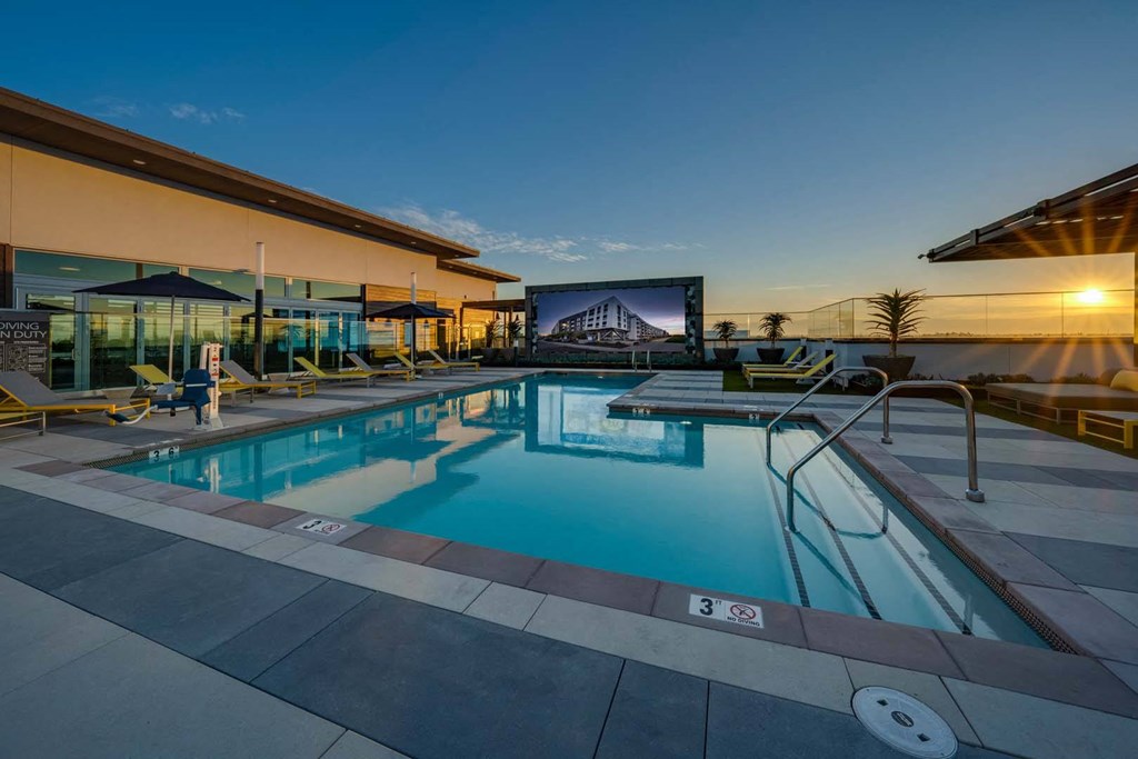 a swimming pool with a large screen in front of a building