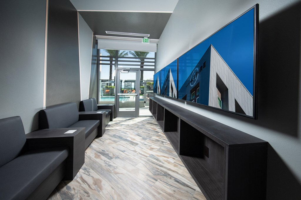 a view down the length of the lobby of a building with black couches and a large