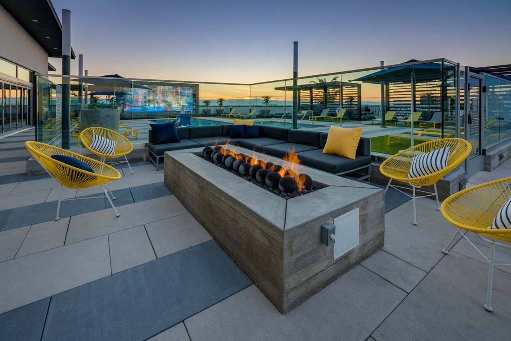 patio with a firepit and yellow chairs