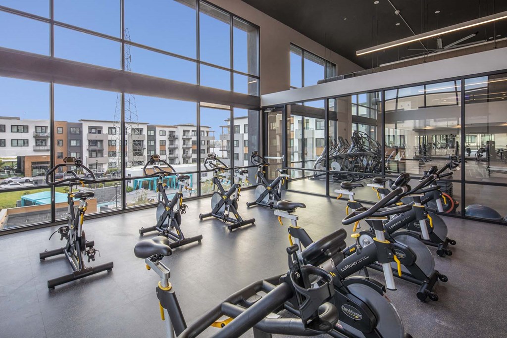a gym with cardio equipment and a view of the pool