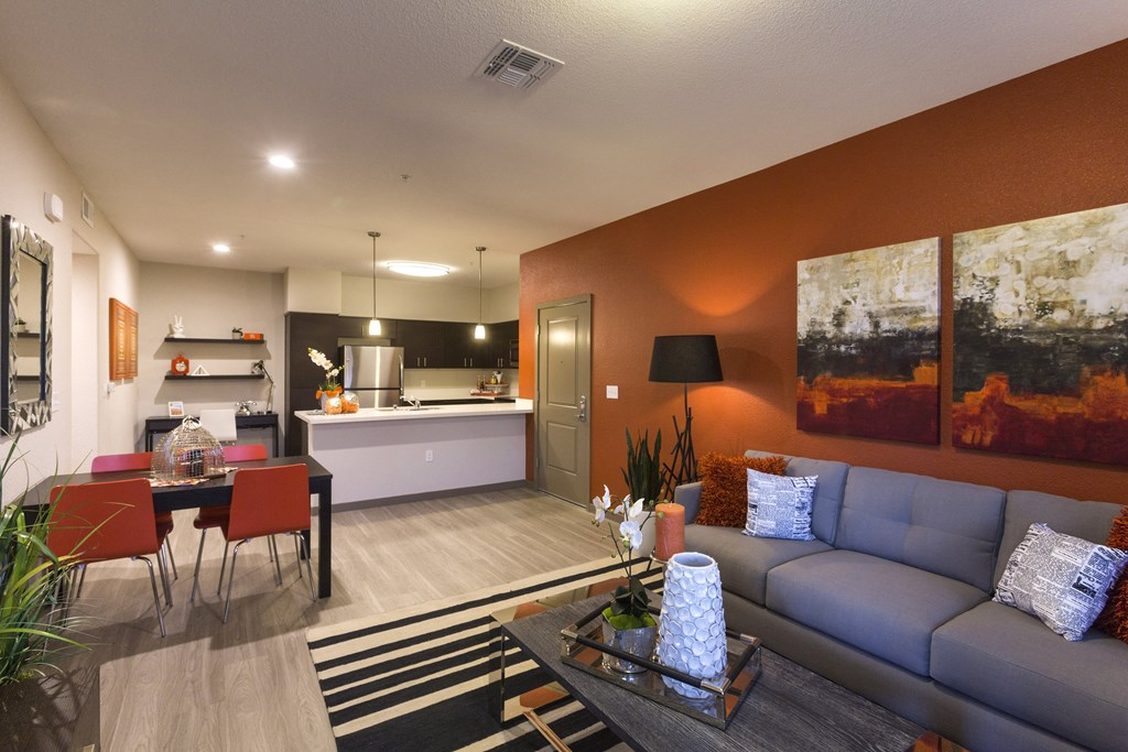 a living room with orange walls and a gray couch