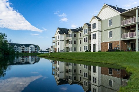 an apartment building reflected in a body of water
