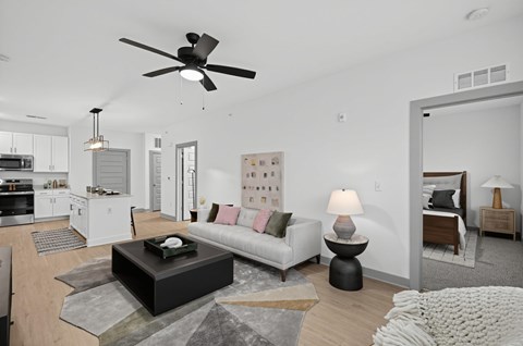 A modern living room with a white ceiling fan and a grey sofa.