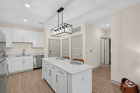 A modern kitchen with white cabinets and a wooden island.