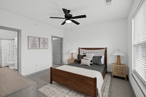A bedroom with a bed, nightstand, and a ceiling fan.