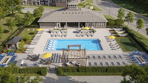 A large outdoor swimming pool area with sun loungers and a building in the background.