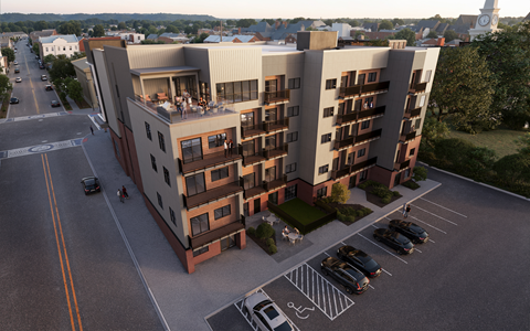 A large apartment building with a parking lot in front.