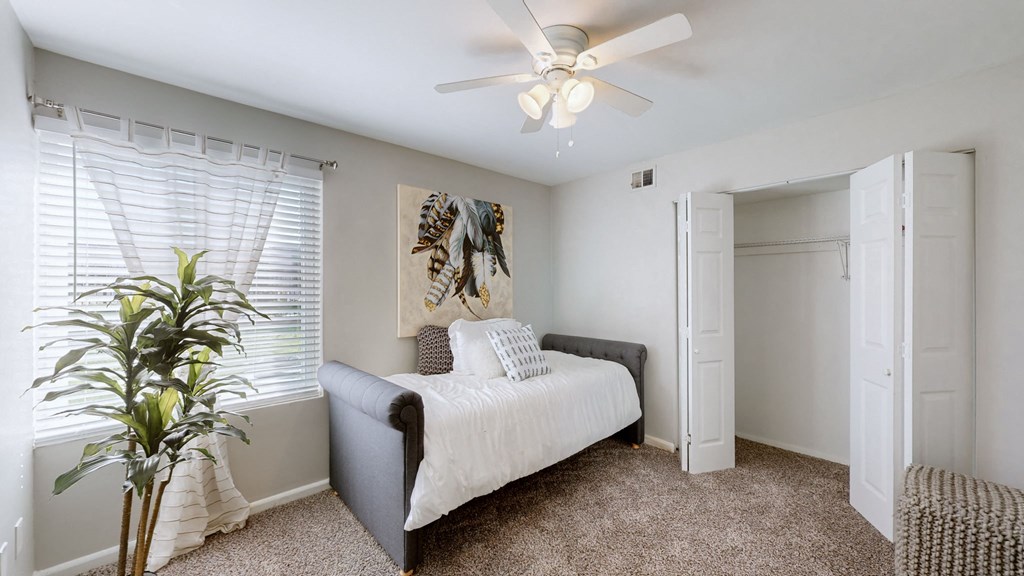 a bedroom with a bed and a ceiling fan