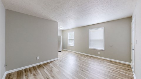 the spacious living room and dining room in a new home with wood flooring