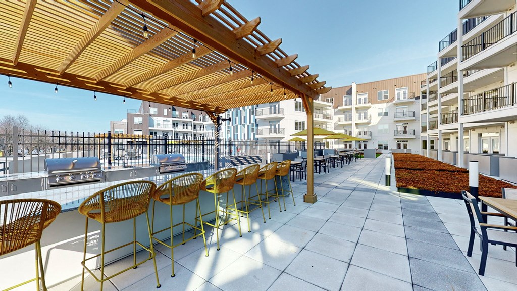 a large patio with tables and chairs and a pergolaat Current812, Clarksville, IN 47129