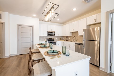 A modern kitchen with a long table and chairs.