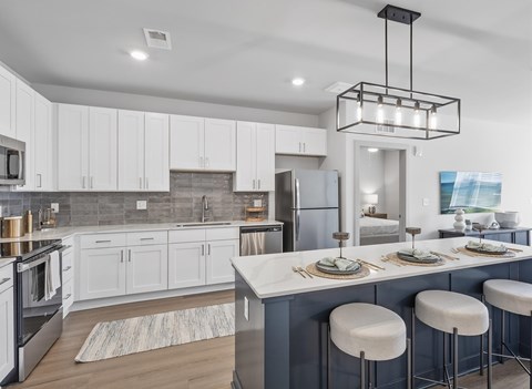 A modern kitchen with a large island and bar stools.