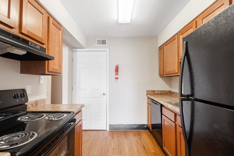 a kitchen with black appliances and wooden cabinets