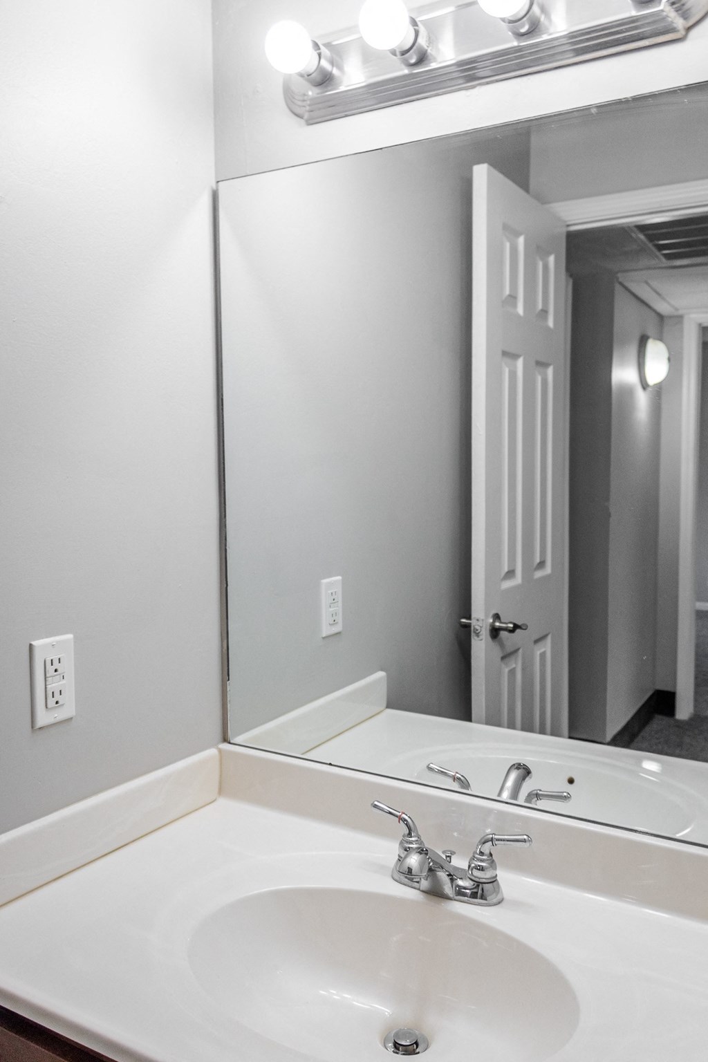 an empty bathroom with a sink and a mirror