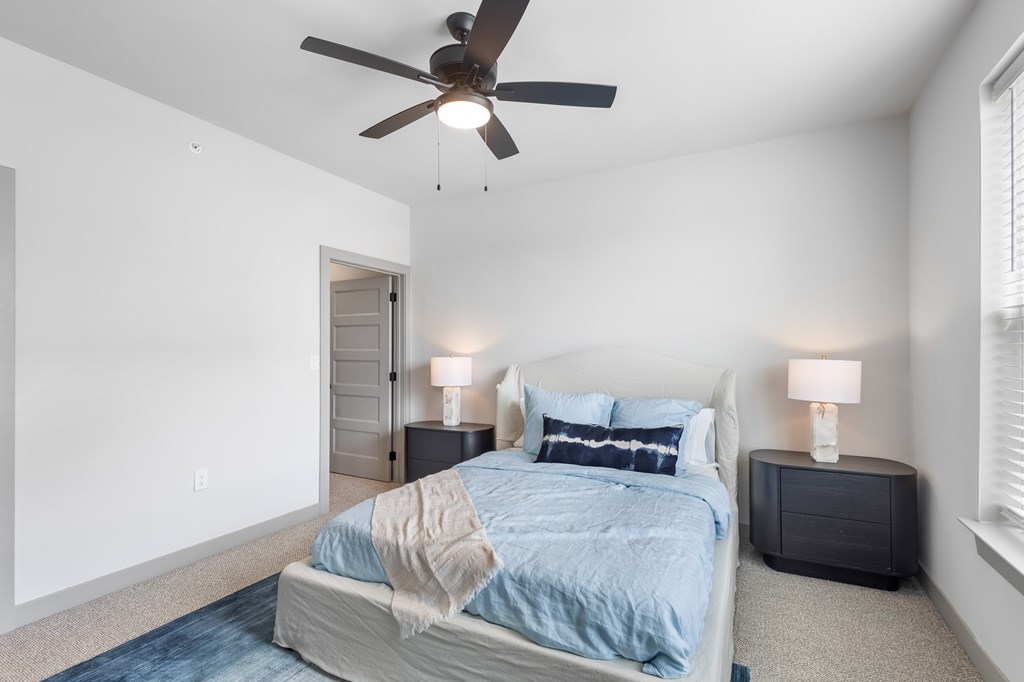 Bedroom with cozy bed and ceiling fan and light at The Warren Apartments, Jeffersonville, IN