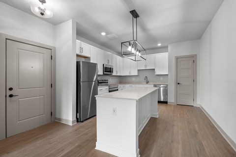 A kitchen with white cabinets and a white island.