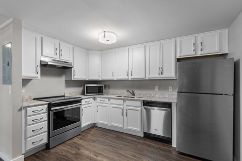 A kitchen with white cabinets and stainless steel appliances.