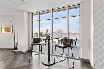 A room with a view of the city through large windows.