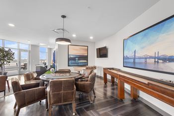 A modern living room with a large painting of a bridge on the wall.