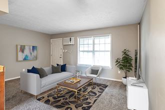 a living room with a white couch and a coffee table in front of a large window - Photo Gallery