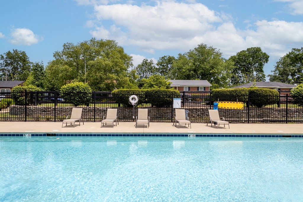 a swimming pool with chaise lounge chairs and trees in the background at Caballo Crossing, Lexington, KY, 40511