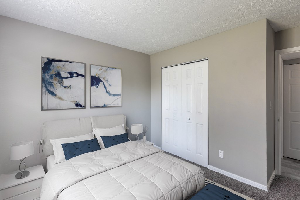a bedroom with a large bed and two paintings on the wall