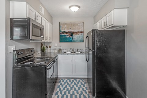 a kitchen with black appliances and white cabinets