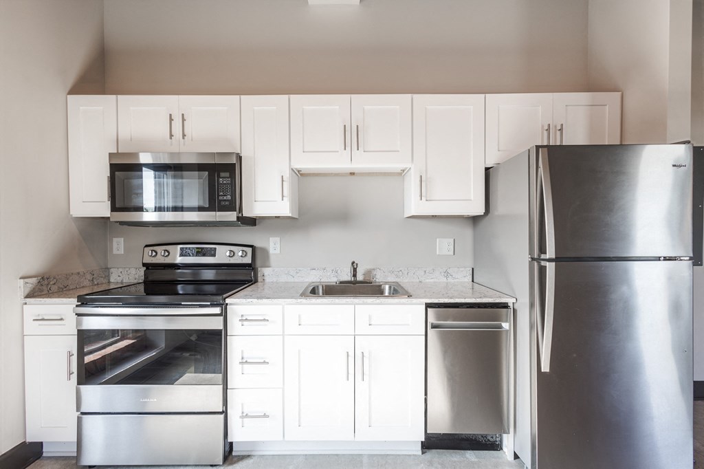 a kitchen with white cabinets and stainless steel appliances