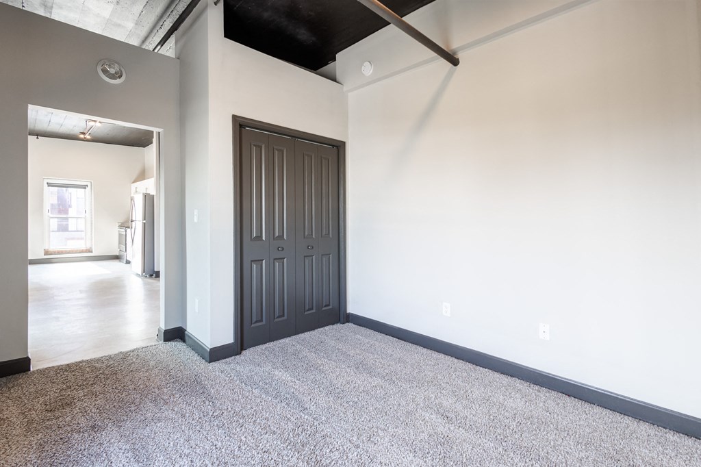 an empty room with white walls and a black ceiling