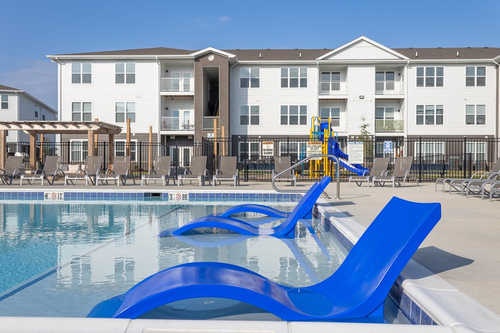 an apartment building with a swimming pool with blue water slides at Arlington Farms, Indiana