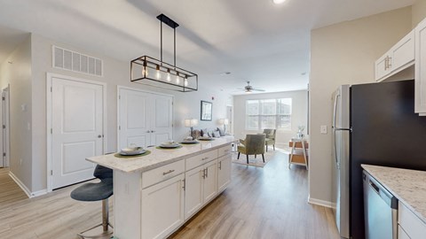 a kitchen with white cabinets and a counter top and a refrigerator