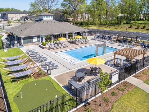 A large outdoor pool area with sun loungers and a putting green.