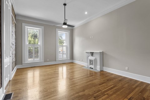 A room with wooden floors and a ceiling fan.