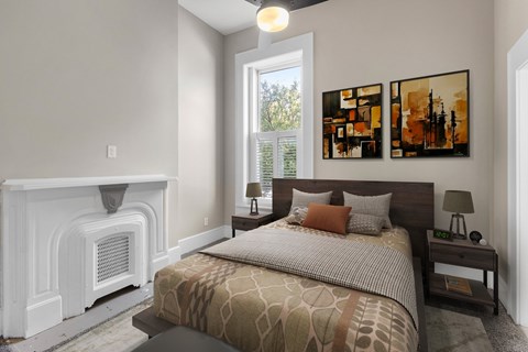 A bedroom with a large bed and a fireplace.