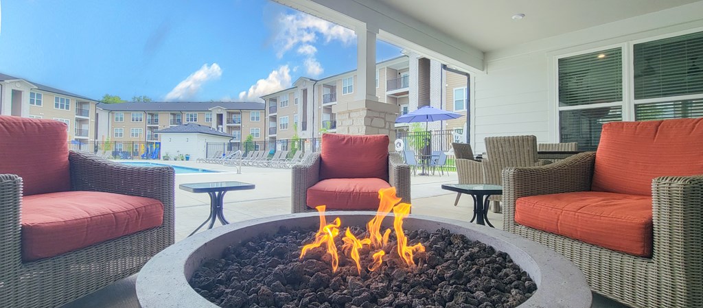 a fire pit with chairs and tables in front of a pool at Sage Springs, Elizabethtown