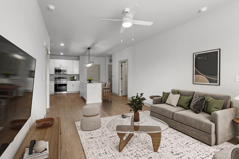 A modern living room with a grey couch and a coffee table in the center.