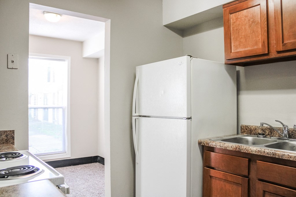 a kitchen with a white refrigerator freezer next to a stove top oven