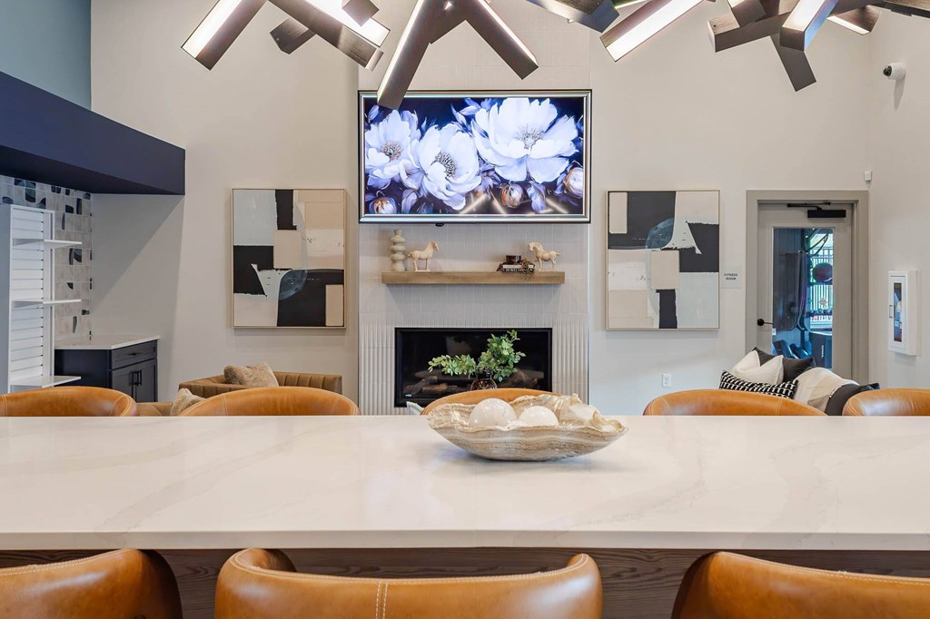 A modern dining room with a large table and chairs. Representative image from a similar completed community.