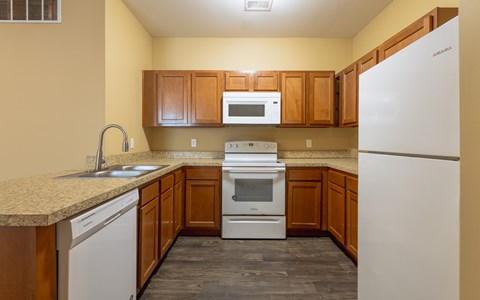 A kitchen with wooden cabinets and a white refrigerator.