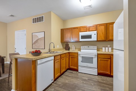 A kitchen with wooden cabinets and white appliances.