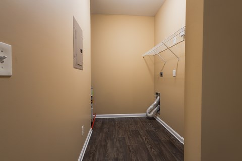 A hallway with a white coat rack and a white light switch.