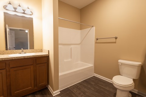 A bathroom with a toilet, sink, and shower.