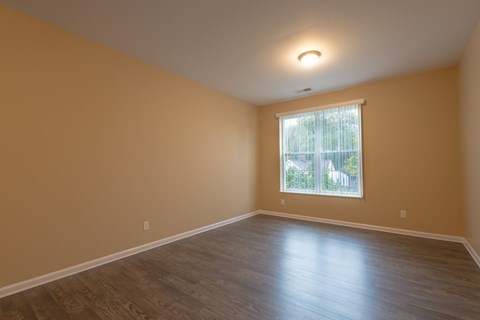 A room with wooden flooring and a window.