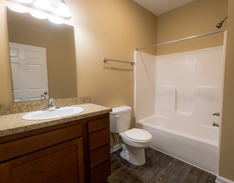 A bathroom with a toilet, sink, and bathtub.