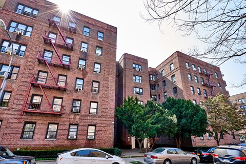 A red brick building with a tree in front of it.