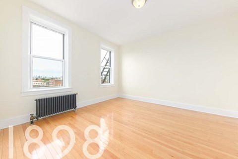 A room with a window and a radiator on the floor.