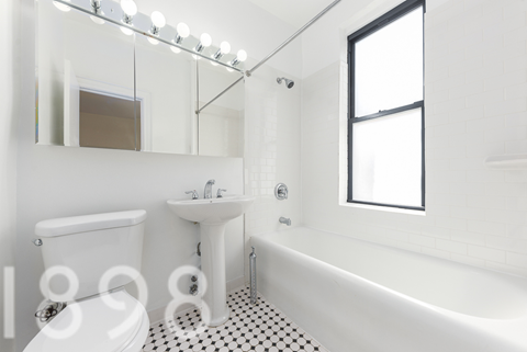 A white bathroom with black and white tiles.