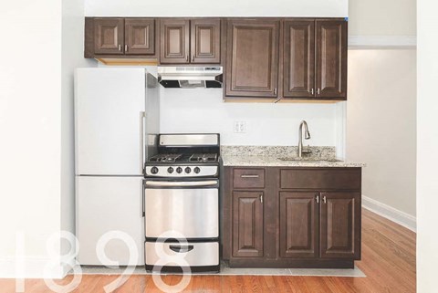 A kitchen with a white refrigerator and stainless steel oven.