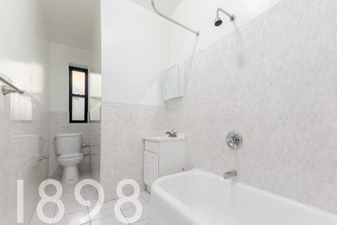 A white bathroom with a toilet, sink, and bathtub.
