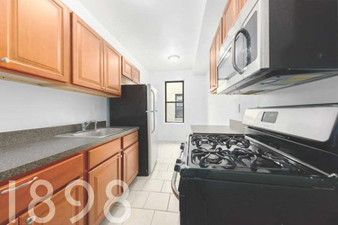 A kitchen with black appliances and wooden cabinets.